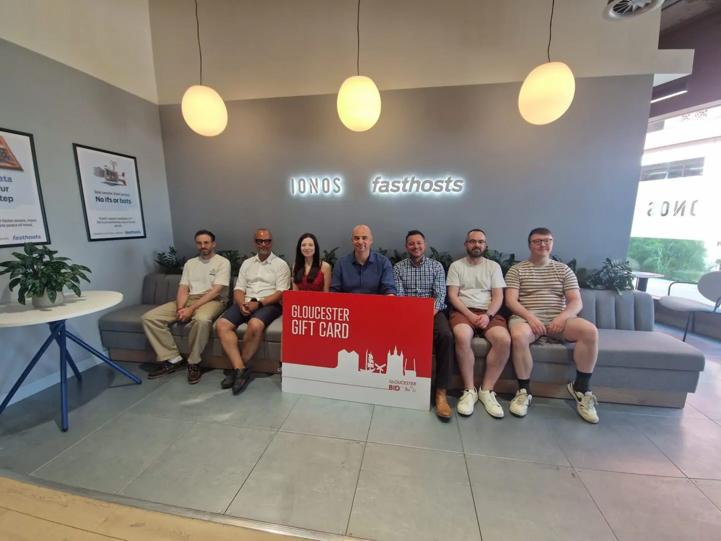Fasthosts team holding a promotional Gloucester Gift Card.